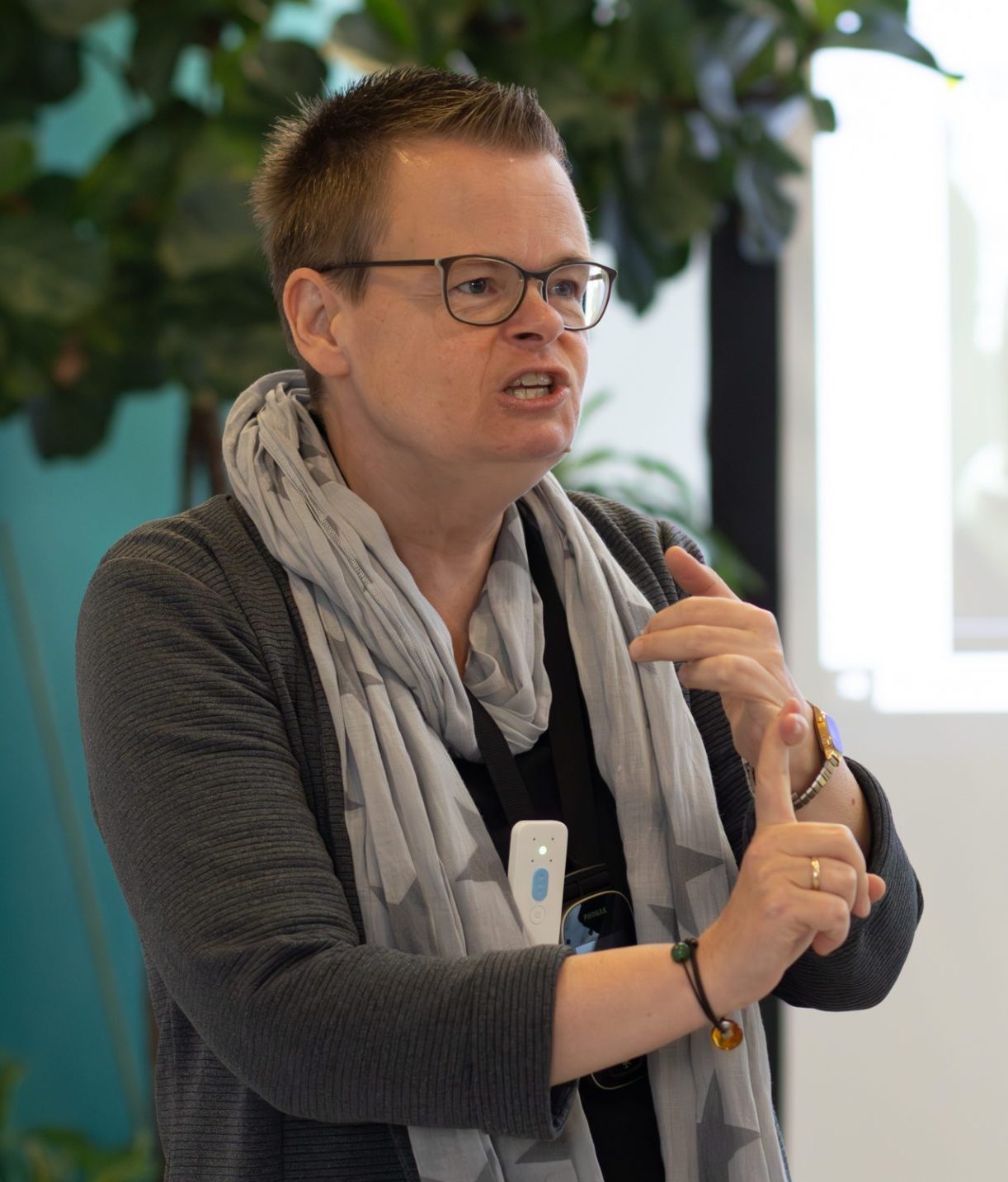 Vordergrund: Dr. Jasmin Schmitz (stellv. Leiterin des Programmbereichs Open Science und Leiterung der Abteilung Publikationsberatung) hält einen Vortrag, Hintergrund: Leinwand mit Präsentation